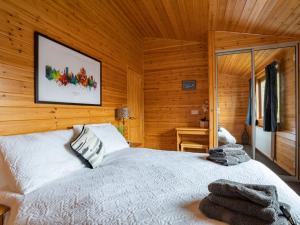 a bedroom with a bed in a wooden cabin at Chalet Loch Leven Lodge 12 by Interhome in Kinross