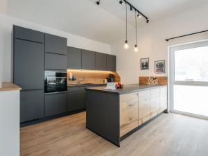 a kitchen with black cabinets and a large window at Chalet Mountain Lodge - Klippitztörl by Interhome in Klippitztorl