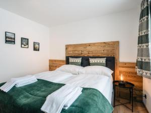 ein Schlafzimmer mit einem Bett mit weißer Bettwäsche und einer grünen Decke in der Unterkunft Chalet Mountain Lodge - Klippitztörl by Interhome in Klippitztorl