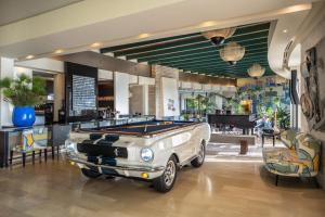 an old car parked in a room with a pool table at Dan Accadia Herzliya Hotel in Herzliya