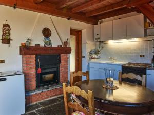 a kitchen with a table and a brick oven at Holiday Home Il Crotto by Interhome in Pianello Del Lario