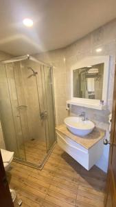 uma casa de banho com um chuveiro, um lavatório e um espelho. em Kaleici Hotel em Antalya