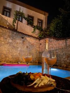 فندق كاليجي  في أنطاليا: طبق من الطعام وكأسين من النبيذ على طاولة