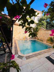 una piscina frente a una casa con flores rosas en Kaleici Hotel, en Antalya