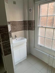a bathroom with a sink and a window at HU1 Triplex City Centre Gem sleeps 6 H7 in Hull