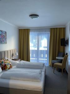 a hotel room with two beds and a window at Hotel HAAS in Bad Gastein