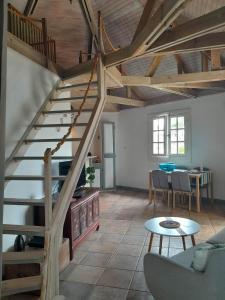 a living room with a staircase and a table at Chalet PLEINSUD in Le Tampon