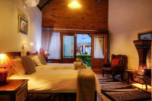 a bedroom with two beds and a table and chairs at Elephants Footprint Lodge in Colchester
