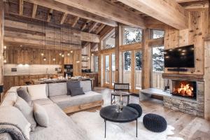 a living room with a couch and a fireplace at Madame Vacances Chalet Atacama in Le Fornet