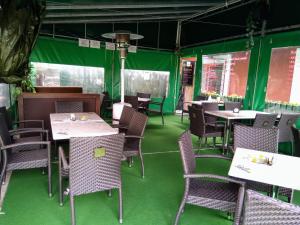 a dining room with green floors and tables and chairs at Penzion Pomodoro in Vrbno pod Pradědem