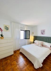 a bedroom with a large white bed and a window at Villa muy cerca de la Playa. in Tías