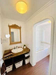 ein Badezimmer mit einem Waschbecken, einem Spiegel und einer Badewanne in der Unterkunft Villa muy cerca de la Playa. in Tías