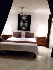 a bedroom with a bed with a face on the wall at Nusa Lembongan Villa Shambala in Nusa Lembongan