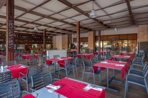 un restaurant vide avec des tables et des chaises rouges dans l'établissement Amara Luxury Resort & Villas, à Kemer