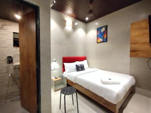 a bedroom with a bed and a bathroom with a shower at Hotel Eros - Near Mumbai International Airport T2 in Mumbai