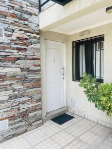 a brick wall next to a white door at Hermoso Departamento Azulino in Mendoza