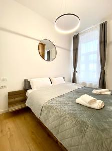 a bedroom with a large bed and a mirror at Green House Studios in Braşov