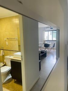 a bathroom with a toilet and a dining room at Hermoso Departamento Azulino in Mendoza