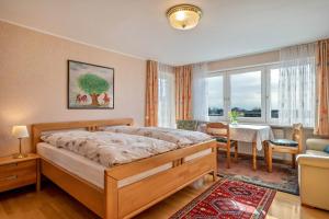 1 dormitorio con 1 cama grande y comedor en Haus Kees - Apartment, en Kressbronn am Bodensee