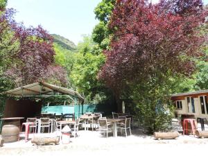 un groupe de tables et de chaises dans une cour dans l'établissement mobil home dans camping 3 etoiles mas de lastourg avec piscine,snack,, à Villefranche-de-Conflent