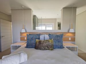 Un dormitorio con una cama con almohadas azules. en Betty, en Plettenberg Bay
