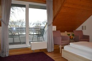 1 dormitorio con 1 cama y balcón en Iris am See garni, en Radolfzell am Bodensee
