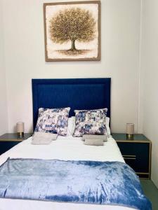 a bed with a blue head board with a tree on it at Cosy Apartment next to Maboneng in Johannesburg