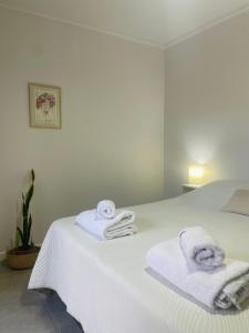 Un dormitorio con una cama blanca con toallas. en Hermoso Departamento Azulino en Mendoza