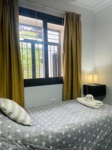 1 dormitorio con 1 cama grande y ventana en Hermoso Departamento Azulino en Mendoza