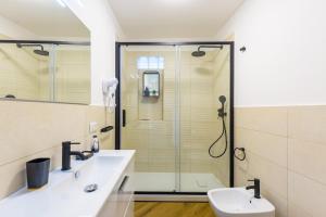 uma casa de banho com um chuveiro e um lavatório. em Poerio Rooftop Luxury apartament em Nápoles