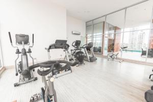 a gym with treadmills and exercise bikes in a room at Boutique Apartments Panamá Coco del Mar in Panama City