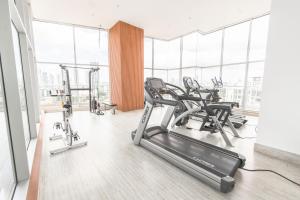 a gym with cardio equipment in a large room with windows at Boutique Apartments Panamá Coco del Mar in Panama City