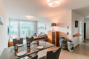 una sala da pranzo e un soggiorno con tavolo e sedie. di Poolhaus Bodensee ideal für Geschäftsreisende a Wasserburg