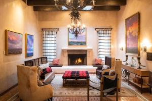 a living room with a fireplace and a chandelier at La Posada De Santa Fe, a Tribute Portfolio Resort & Spa in Santa Fe