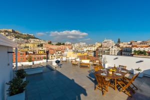 uma varanda com uma mesa e cadeiras e uma cidade em Poerio Rooftop Luxury apartament em Nápoles