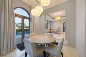 een eetkamer met een tafel en stoelen bij Maison Privee - Private Pool & Beach Access Villa with Cinematic Vws in Dubai