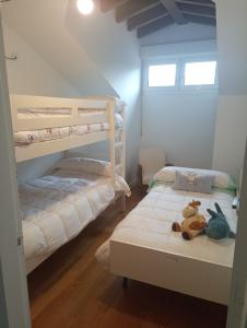 two bunk beds with stuffed animals sitting on them in a room at Dúplex en Comillas in Comillas