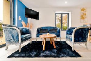 a living room with two blue chairs and a table at Maison au bord de la Moselle in Argancy