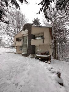 un edificio con nieve en el suelo delante de él en Villa Alexa en Borovets