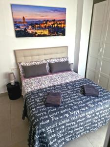 a bedroom with a bed with a picture on the wall at APARTAMENTOS ELEMAR free luggage storage in Málaga
