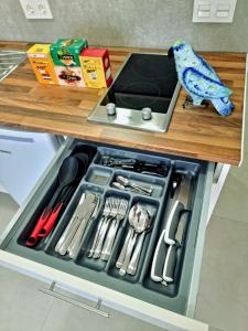 a drawer filled with utensils on a kitchen counter at APARTAMENTOS ELEMAR free luggage storage in Málaga