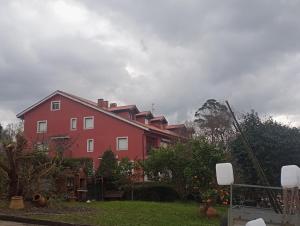 a red house in a yard with at Dúplex en Comillas in Comillas
