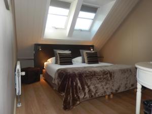a bedroom with a bed in a attic with skylights at B&B De Passant in Breskens