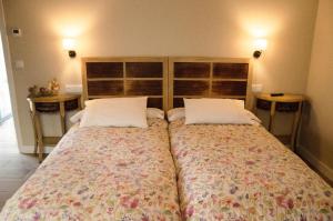 1 dormitorio con 2 camas y 2 mesitas de noche en A Casa da Fonte, en Ourense