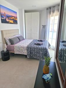 a bedroom with a bed and a pineapple on a table at APARTAMENTOS ELEMAR free luggage storage in Málaga