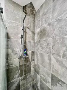 a shower with a shower head in a bathroom at Dunamis Staycation 4 in Croydon
