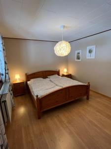 a bedroom with a bed and a chandelier at Ferienhaus in Broakulla mit Sauna in Broakulla