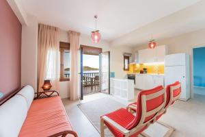 a living room with a couch and chairs and a kitchen at Nereus & Oceanus Beachfront Apartments, Lagonisi Beach #FeelsLikeHome in Ormos Panagias