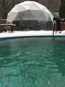 ein Schwimmbad mit Sonnenschirm im Schnee in der Unterkunft ozlifesapanca dome in Sapanca