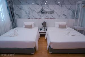 2 łóżka w pokoju hotelowym z białą pościelą w obiekcie Siam Best Inn w mieście Makkasan